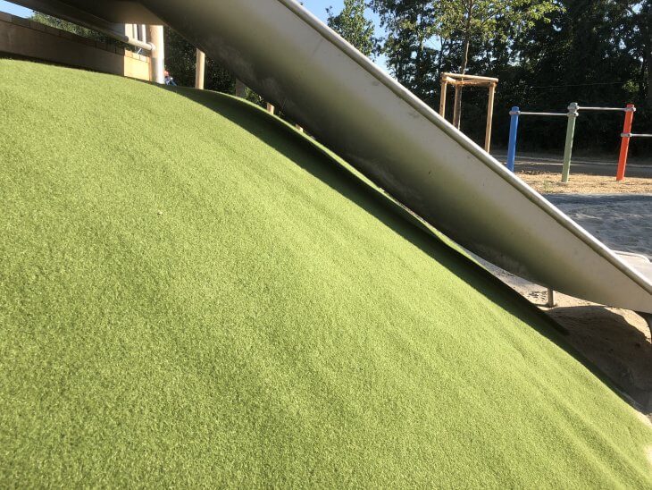 Das grasgrüne Teppichvlies von ChildsPlay im Einsatz für die Hangsicherung einer Rutsche