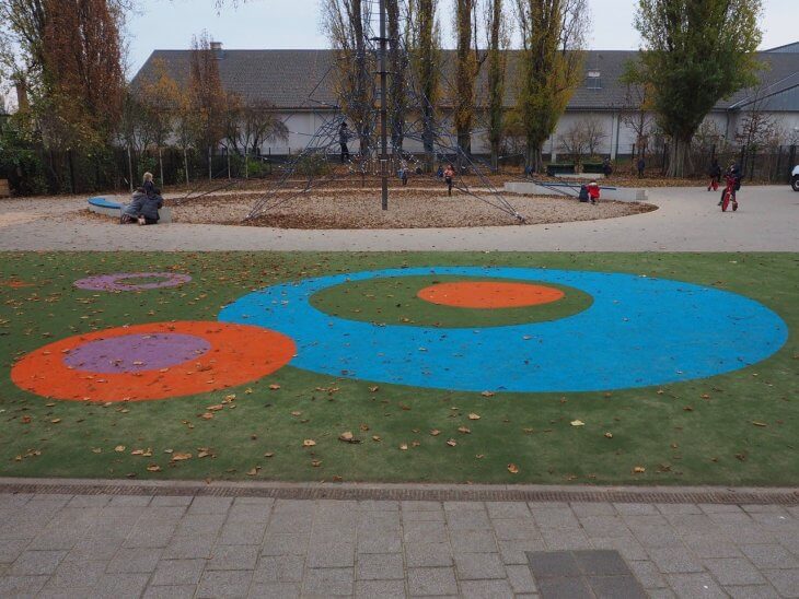 Bunte Spielkreise im Teppichvlies sorgen auf dem Pausenhof der Kiefholz-Grundschule Berlin für optische Highlights.